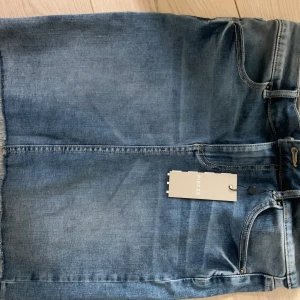 Jeanskjol - Superfin jeanskjol, med fransar nedtill. Aldrig använd & prislapp kvar. Säljer för att jag har 10 andra jensskjolar. 