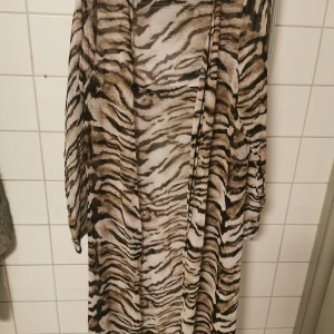 Strandklänning  - Strandklänning one size. Genomskinligt svalt material. Slits nere vid båda benen. 