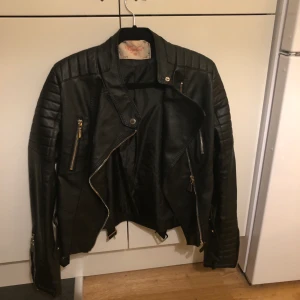 Svart bikerjacka - Svart bikerjacka i läderimitation i storlek 38 (small). Köpt på Chiquelle.se (”Moto jacket”). Endast använd 1 gång.