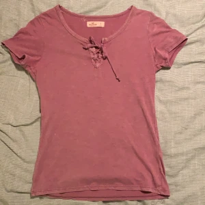 T-shirt med snörning - T-shirt med snörning i jättefin gammelrosa färg ifrån Hollister. Storlek S! 👚