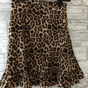 Leopard kjol från NA-KD - Fin leopard kjol från NAKD i nyskick. skönt material med en lite lösare passform och en fin volangkant. Storlek 32 men skulle säga att den även passar en XS.💕