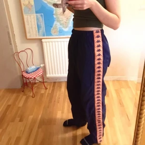 Kappa trackpants strl S-L - Snygga mörkblå och orangea kappa trackpants som jag säljer för att jag trodde jag skulle använda de mer än jag gör... superbra skick och kan knäppas upp längs benen med en dragkedja! 