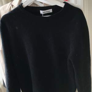 En svart ylletröja från Balmain, köpt via Veistaire Collective där den blivit autentiserad. Lappen på tröjan är kvar. Är i storlek S/M men passar även XS för lite mer oversized. Säljes för: 700kr eller högstbjudande. Fler bilder kan skickas på begäran.