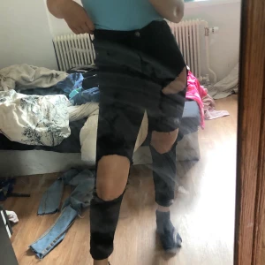 Högmidjade svarta jeans  - Svarat jeans med hål i