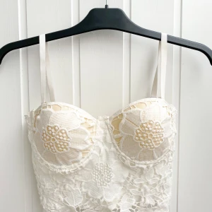Vit Korsett topp - Topp med blommor och detaljer, har med följande på och av tagnings bara band, har korsett rygg där det går att reglera själv storlek som passar just dig. Använd 1 gång. 160 kr ink frakt .