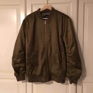  - Bombarjacka från Bikbok i strl XS/34. Rymlig, dragkedja fungerar, fickor finns. Färgen var svår att fånga men den är olivgrön/guld. Hund finns i hemmet