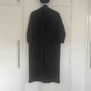  - Granitgrå matt lång tunn rock i silke, Snygg trendig passform, Stora ytliga fickor, Ankellång, V-cut baktill