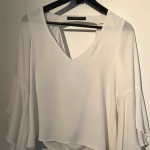  - Superfin vit topp från zara med volangärmar. Djupt skuren i ryggen. I fint skick! Finns i Stockholm alt Huddinge. Frakt 39kr 