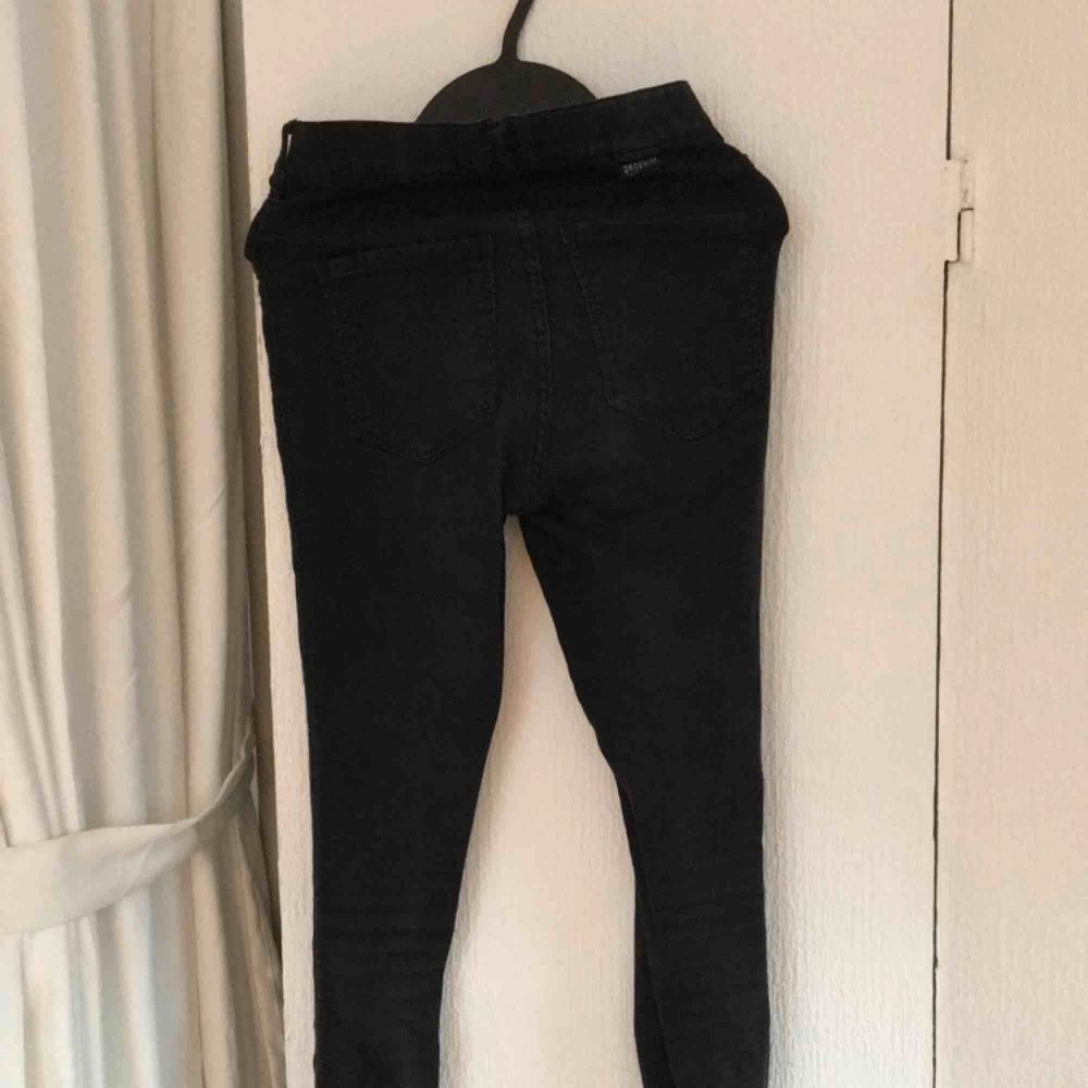 Svarta högmidjade dr. Denim jeans. De är ganska använda så dom har blivit lite urtvättade och en söm på bakfickan har gått sönder (dock enkelt att laga), annars är dom i fint skick. Betalas med swish, 30kr +frakt. Fråga gärna frågor!. Jeans & Byxor.