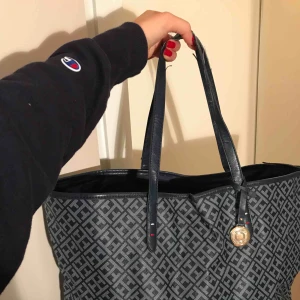  - Tommy Hilfiger-väska i snygg färg och mönster. Banden är en lite slitna men annars är väskan i fint skick! Säljer även samma modell fast i vit. 