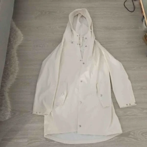  - Vit regnkappa. Använd mindre än 5 gånger. 