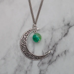  - Fint halsband med glaspärla. Hänget är ca 4cm. Kedjan är ca 50cm. Fri frakt vid köp över 100:-.