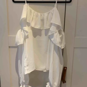  - Vit tunn blus med tunna band och öppna axlar. Aldrig använd. 