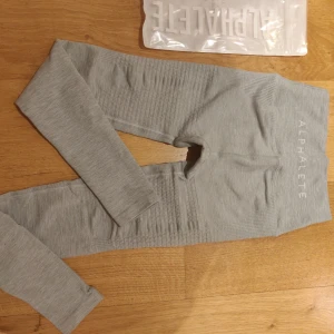  - Alphalete Halo leggings cloud grey   Oanvända, endast testade men för små för mig. Säljes då det kostar att returnera. De har slutat ha lappar på sina produkter då de ändå kommer i dustbags, därav inga lappar. Nypris ligger runt 630 kr. Säljer för 480 kr :)