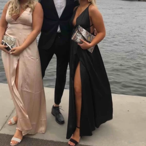  - Svart balklänning. Endast använd en gång och är i nyskick. Öppen rygg, slits på benet och justerbara band i nacken. Köpt för 1799. Skriv gärna för fler bilder!