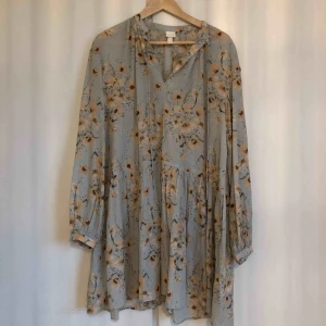  - Mintgrön blommig klänning med volangdetaljer. Lite oversized. Använt 2-3 ggr. Djur och rökfritt hem. Frakt: 30 kr