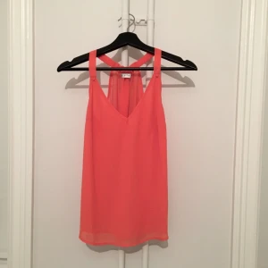  - Söt topp, skulle säga att den är orange/rosa/korall-färgad! 