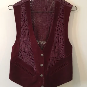  - Lila/vinröd vintage väst i mocka och virkat. Köpt second hand i LA. Ingen storleksmärkning men S-M beroende på hur man vill att den ska sitta. Köparen betalar porto. 