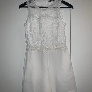 Jumsuit  - Vit jumsuit med spetsdetaljer. Storlek 38 (mer som 36). Först till kvarn på alla plagg, ingen budgivning. Ange vilket pris du skulle vilja köpa plagget för så kan vi komma överens om ett bra pris där båda blir nöjda. 