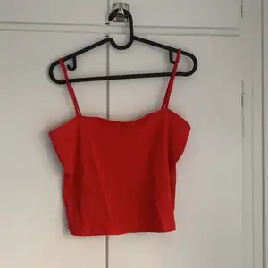 Rött croppat linne med rak urringning. Sparsamt använd. Den är lite skrynklig nu då den legat i garderoben länge.