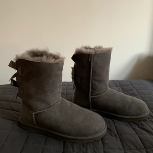 Uggs - Helt oanvända snygga och äkta grå Baily Bow ii UGGS. Säljer dem för halva priset, originalpriset ligger runt 2000 kr, men priset kan diskuteras. Kan mötas upp i Stockholm eller 
