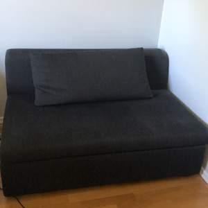 En liten svart soffa som är perfekt att ha i sitt rum!
