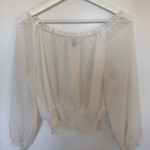 Topp H&M strl. 34 - Vit Off shoulder topp/blus från H&M i storlek 34/XS men passar även S. Köparen står för frakt men kan mötas upp i Växjö. 