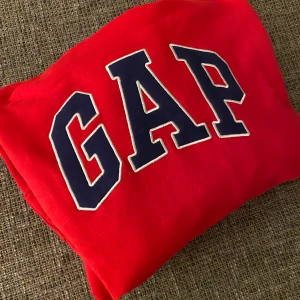 GAP Hoodie - Helt oanvänd (endast testad) röd & marinblå GAP hoodie. Inköpt i London i februari men säljer pga felköp :( Superfin & mjuk tröja! Köparen står för frakt / eventuellt mötas upp i Nyköping 