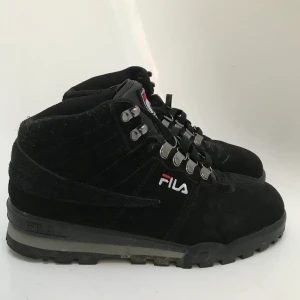 Fila svarta kängor size 41 - Feta Fila kängor i färgen svart. I stor sett nyskick (bara använda 2/3 gånger!) Riktigt coola men inte fått användning av dem. Det är bara att buda på helt enkelt!!