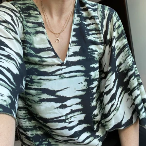 Jättefin top med vida ärmar - Sjukt snygg top/blus! V-ringad både fram och bak, vida kvartslånga ärmar. Bra skick! Frakt tillkommer