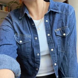 Cool jeansskjorta från Lee - Snygg både som overshirt eller knäppt! Vita tryckknappar och logga på bröstfickan. Bra skick! Frakt tillkommer 
