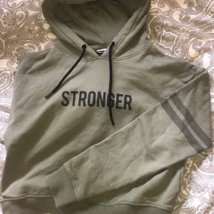 Grön croppad stronger hoddie  - Finns ej kvar på hemsidan då det var en tillfällig produkt. Använd 3 ggr. Inte nopprig eller sliten och den är fortfarande mjuk på insidan trotts tvättad. Nypris 499kr eller 599kr. Jag säljer den för 70kr. 