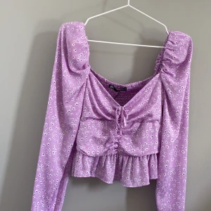 Lila blommig blus från Zara - Lila blommig blus från Zara i storlek M. Helt oanvänd! Frakt tillkommer!