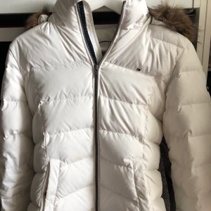Dunjacka från Tommy Hilfiger  - Denna snygga jacka kommer från Tommy Hilfiger. Jag har inte använt den så mycket och därför säljer jag den. Den är i mycket bra skick. Sitter bra i midjan och man kan även bära en stickad tröja eller liknande under. Ordinariepris 2000 kr. 