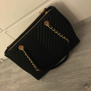  - Svart väska med gulddetaljer, aldrig använd, inte min stil, perfekt skick, frakt ingår