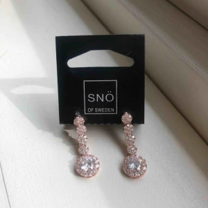  - Säljer dessa oanvända örhängen från Snö of Sweden. Rosé och silver. Längen är cirka 3,5 cm