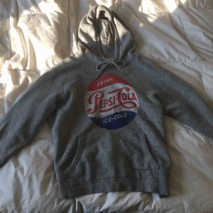  - Grå, vintage hoodie i ljusgrå färg. Pepsi-cola tryck. Ficka på magen samt luva. Använd få gånger. Passar även folk med strl. S eller folk med XS men då lite oversized. 