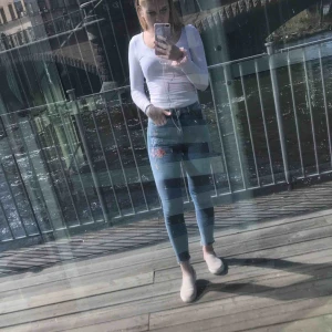  - Jag säljer ett par jeans från H&M, dom har blommor broderat på vänster ben. Stl: 34 Dom kommer från ett djur och rökfritt hem.