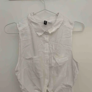  - Kort vit knytblus utan ärmar.   Köparen står för porto. 