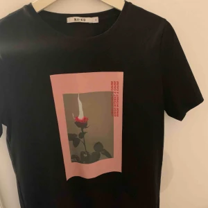  - Svart T-shirt med tryck från nakd. Köpt för 200 kr men går och buda på priset.