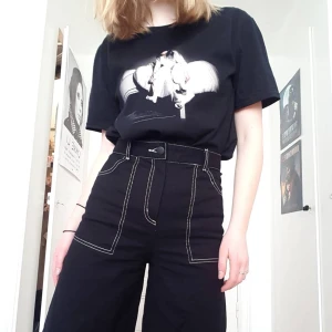 Svarta brallor med vita sömmar - Ascoola svarta byxor med vita sömmar, hög smal midja och vida ben! Nästan helt nya och säljer endast då jag har ett annat par nästan exakt likadana! 