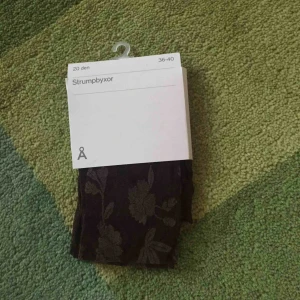  - Oanvända strumpbyxor i brunt med blommor.