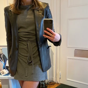 Grå klänning med ärmdetaljer - Grå klänning från zara i bomull! Långa band som man tar några varv runt midjan ock knyter, man kan anpassa längden beroende på hur man viker upp klänningen och knyter banden. På bilden jag har jag dragit upp den lite grann. Jätteskön och använd ca 5-6 gånger! Säljer pga för mycket kläder i garderoben :))