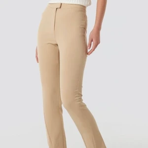 Nakd kostymbyxor med slits - Säljer mina beigea kostymbyxor med slits från Nakd, aldrig använda därmed prislapp kvar. Storlek 36. 200kr+frakt