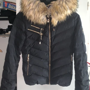 Hollies jacka strl 34  - Säljer min hollies jacka strl 34. Använd vinter 2018. Har tvättat den så man behöver kamma ut pälsen. Säljes pga inte min stil längre så ligger bara här hemma. Nypris 3000