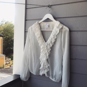  - Säljer denna superfina blusen som jag verkligen har tyckt så mycker om från Nelly. Vitt transperant tyg och med fina volanger på, funkar bra med linne under också om man inte vill visa för mycket. 💕 Sparsamt använd! 