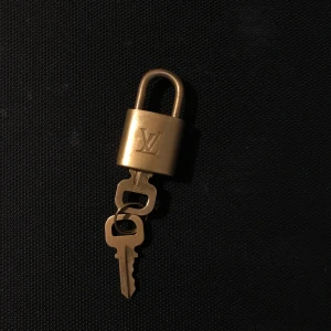 Luis Vuitton lås  - Guld LV lås med 2 nycklar utan kedja, nästan som nytt inga större skador endast lite repor som inte syns (8/10 i skick) budgivning startar vid 350 och köparen står för frakten!