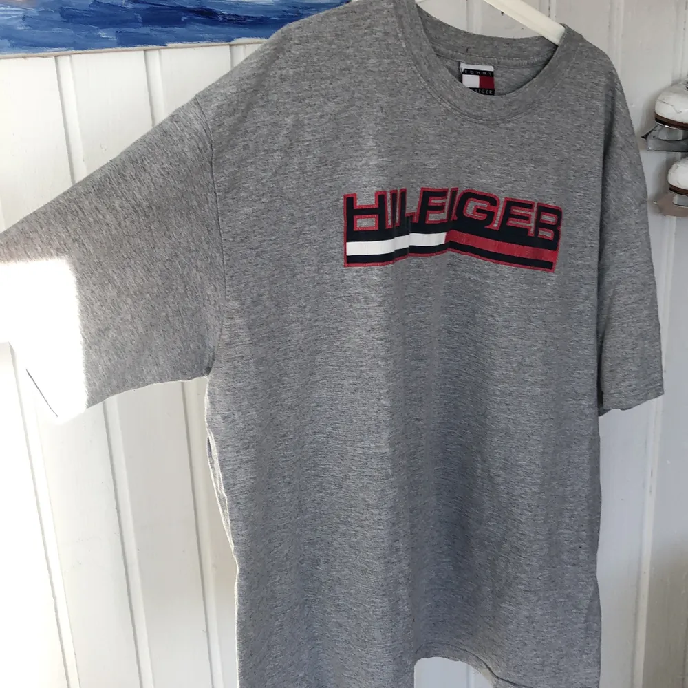 Äkta Tommy Hilfiger t-shirt inköpt 2002 i LA. XXL men mer som XL. . T-shirts.