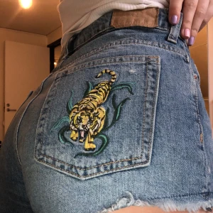 Shorts med tiger - Snygga shorts från HM med en tiger på ens bakfickan 🐯🐯 På främre fickan står det hola chica också!! HIGHWAISTED