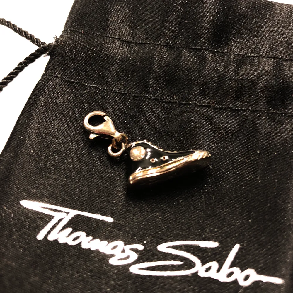 Säljer denna Thomas Sabo berlock i form av en svart Converse sko. Fått i present men aldrig använt den. Kommer putsa till den med silverputs vid försäljning för att den ska bli mer silvrig. Påse medföljer. Frakt ingår😀. Accessoarer.